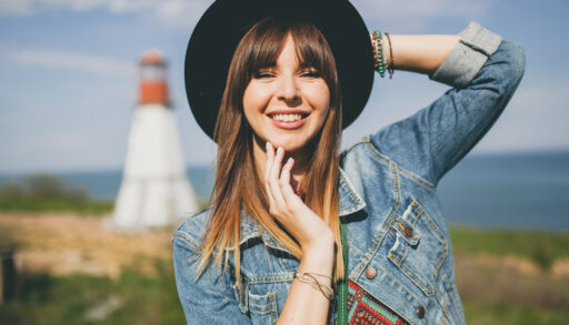 girl wearing hat and denim jacket in the sun
