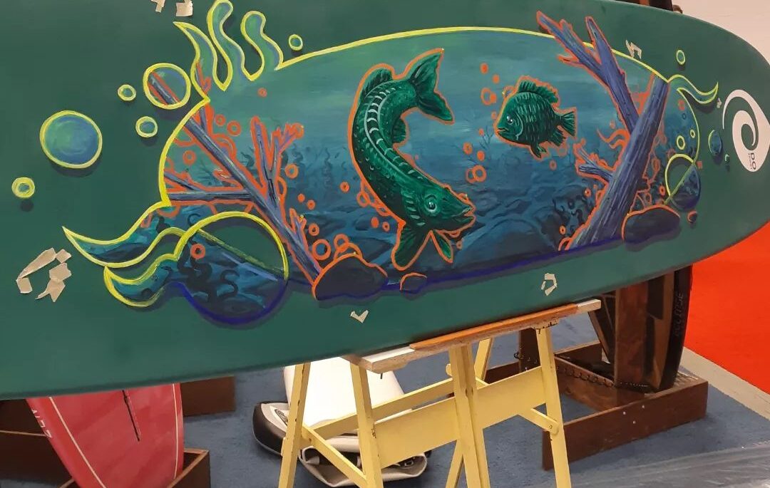 paddleboard with green fish painted on