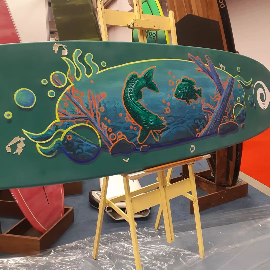 paddleboard with green fish painted on