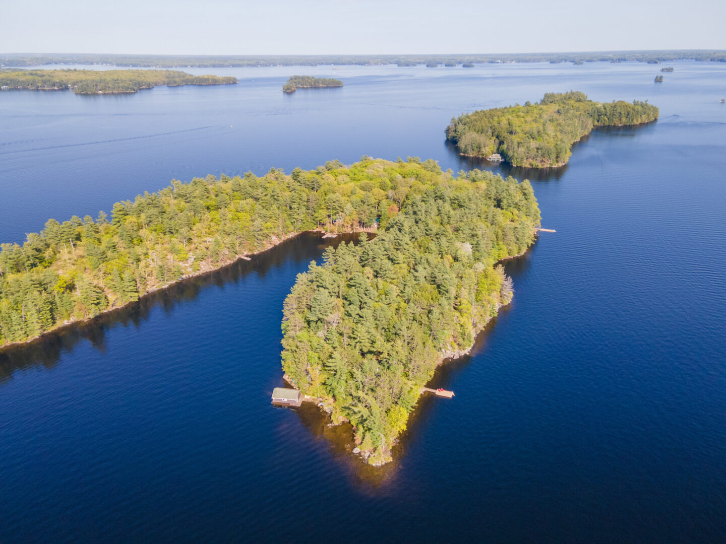Overhead view of a small island with an angular peninsula, surrounded by deep blue lake.