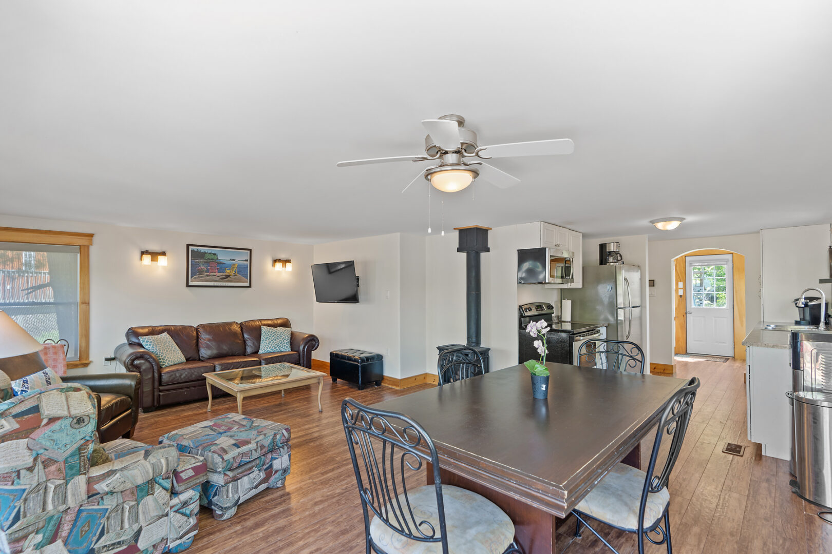 An open-concept cottage interior with a living area, a dining area, and a kitchen.