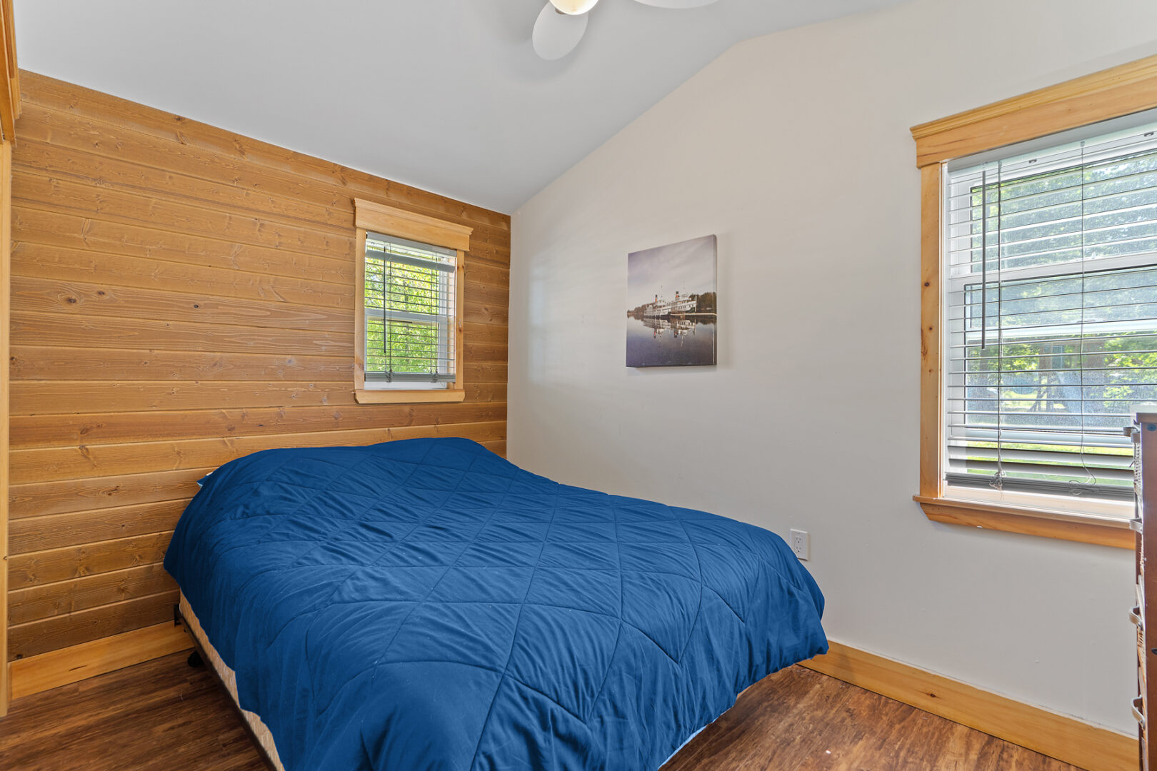 A small, simple bedroom with a medium-sized bed and a small window.