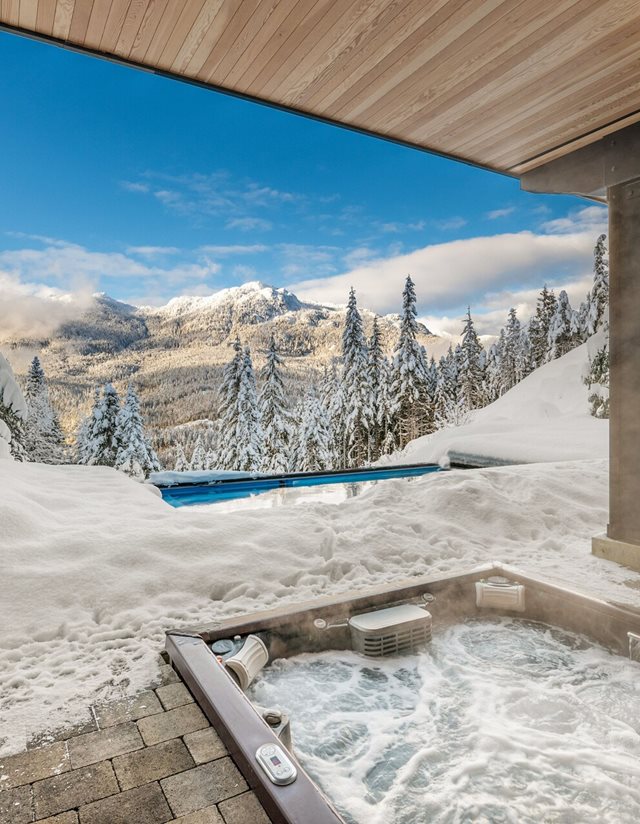 view of the snowy mountains from the back porch hot tub at midday
