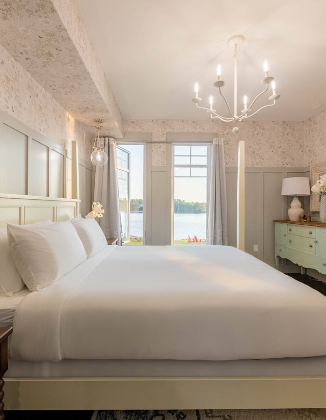 master bedroom with white bedding and walls