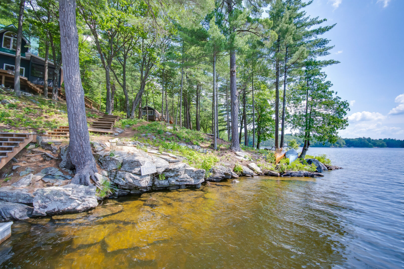 A long stretch of shallow shoreline on a rocky, tree-lined area.