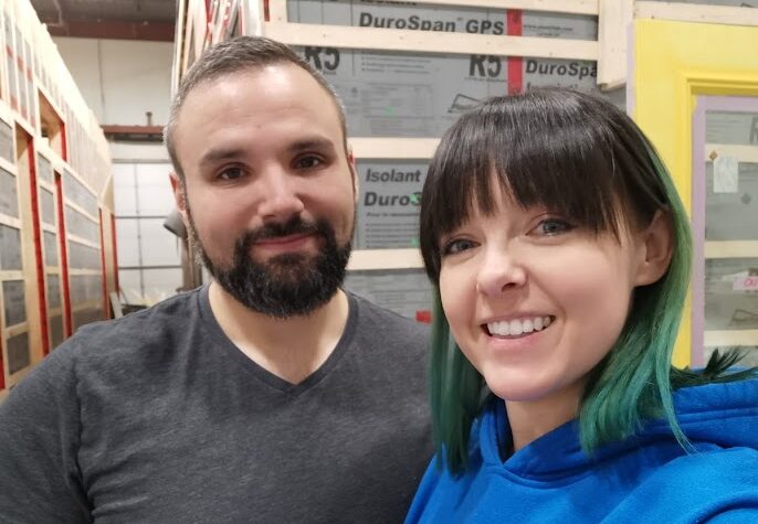 Photo of the couple in the warehouse where their tiny home was being built