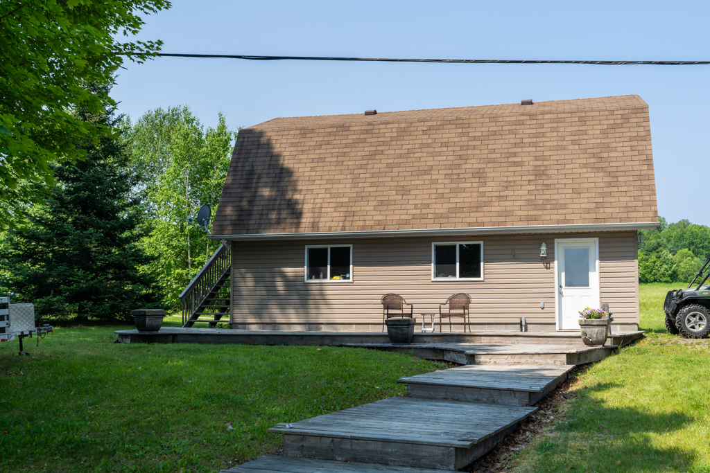 A wooden deck sits in front of a detached garage.