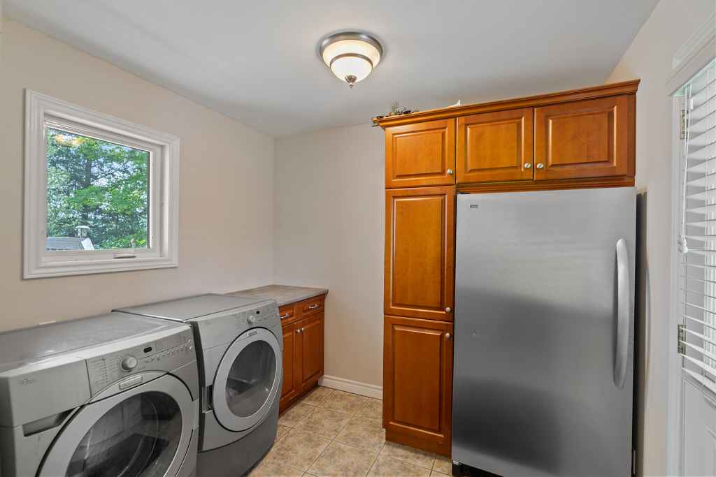 A modern washing machine, dryer, and large fridge.