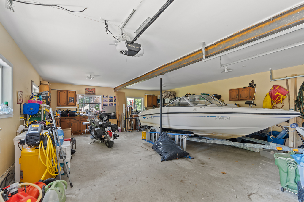Interior of a garage with a big boat and lots of storage space.