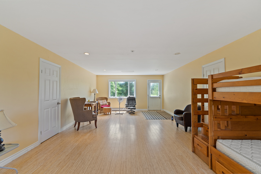 Interior of a bright second-floor loft space in a detached garage, with hardwood floors and a bunkbed.