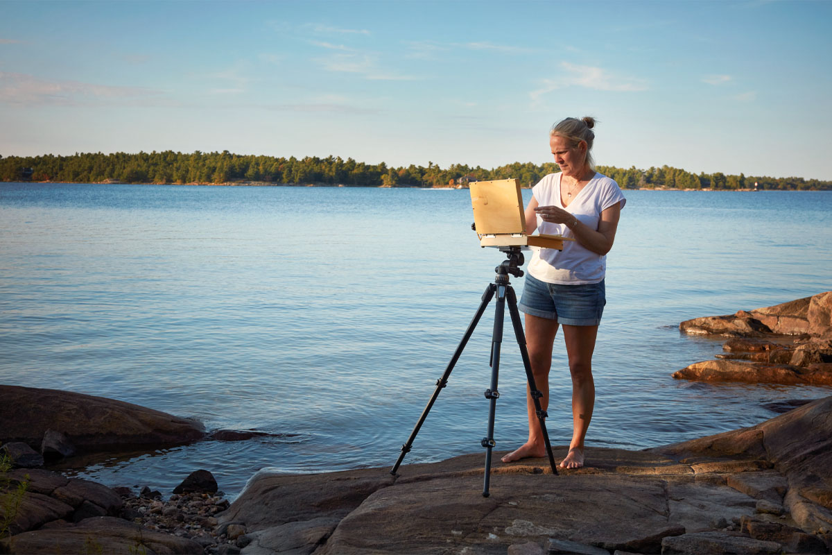 Kara outside painting on the rocks
