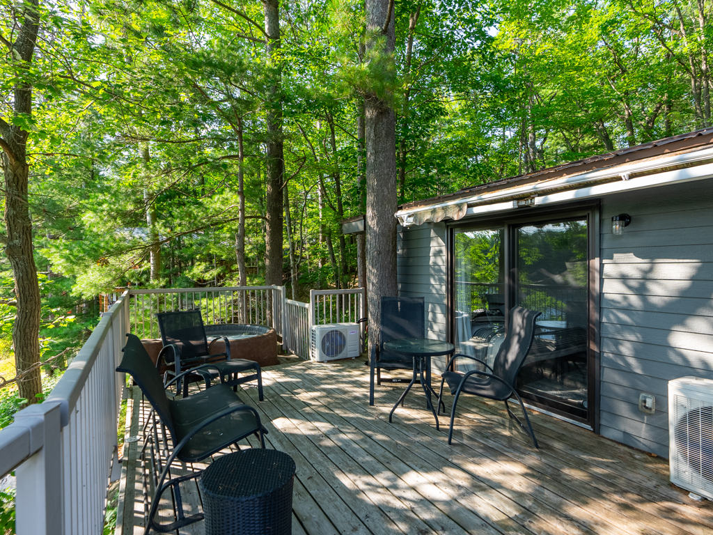 A shady deck off a cottage with some space to sit.