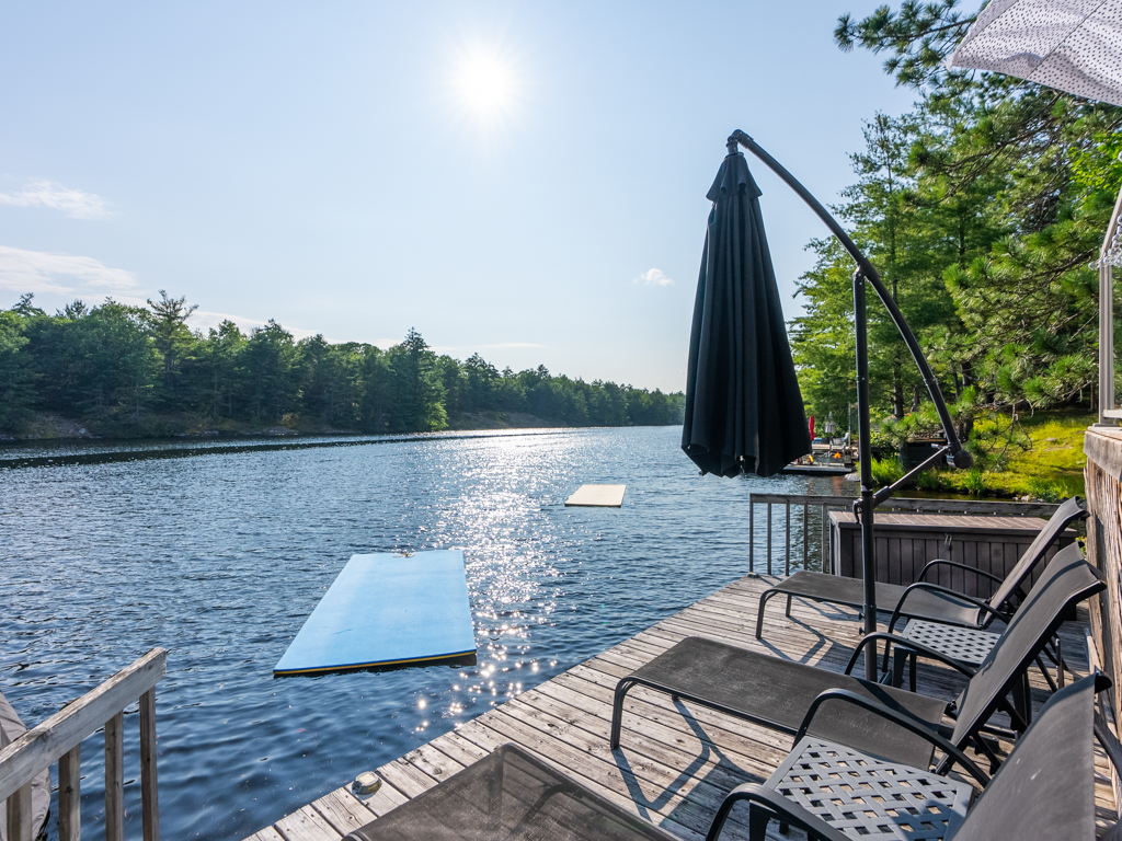 A shallow stretch of dock with lounge chairs, looking out across the lake.