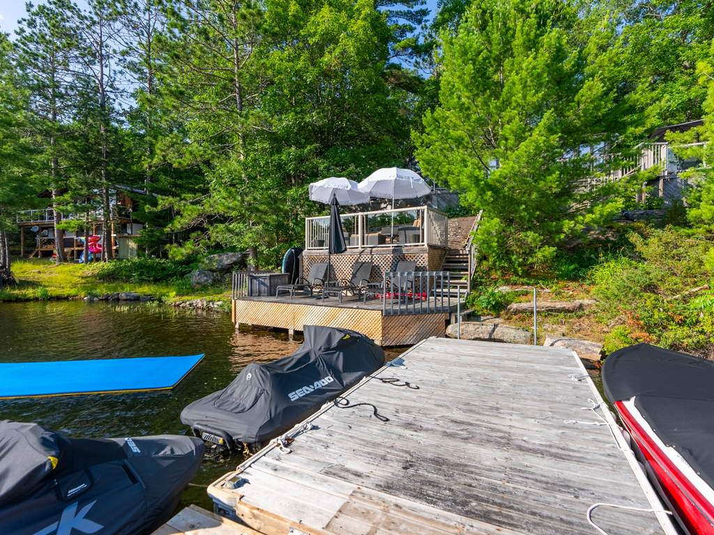Looking up toward a cottage from a long dock on the lake.