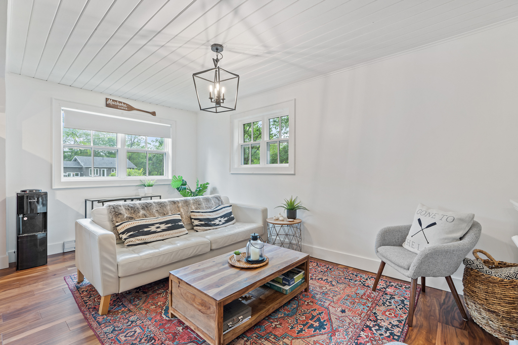 A bright living space with hardwood floors, a gray couch, and a coffee table.