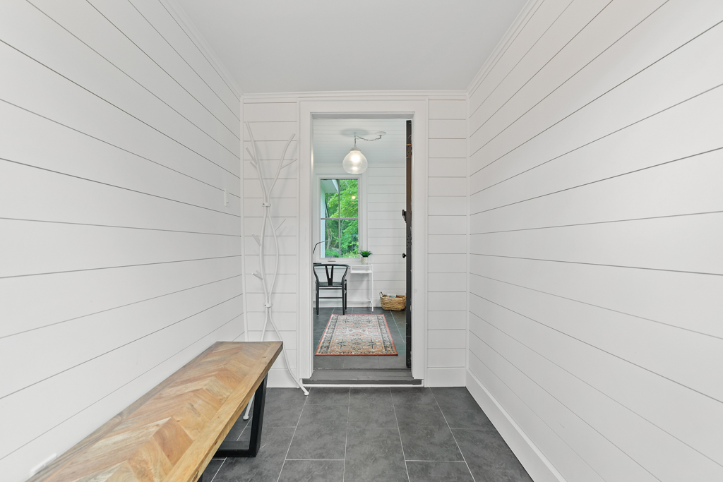 A narrow front hallway with a bench.