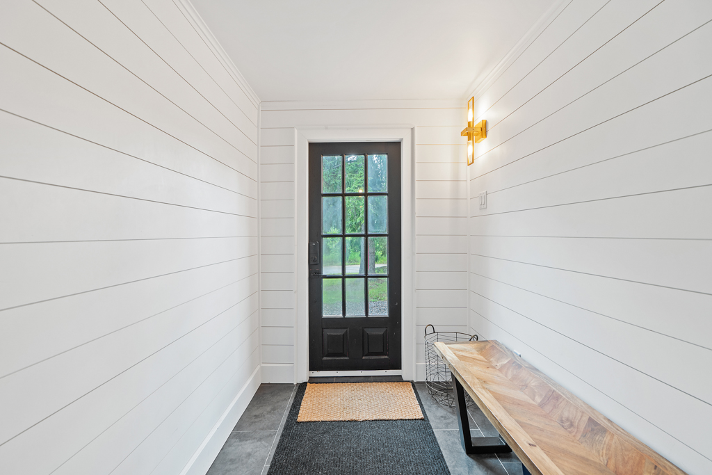 A narrow front entrance hallway with a bench, just inside the front door.
