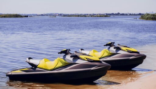 Two jetskis (PWCs) sitting on a beach shore