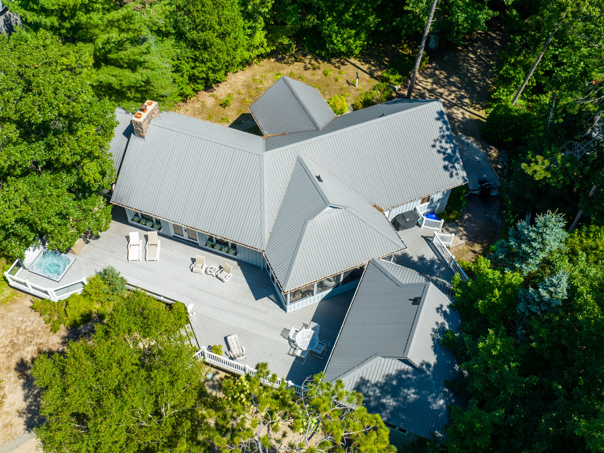 Overhead view of a large, luxury cottage with a grey roof.