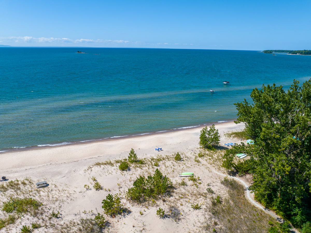 A sandy beach in front of blue water.