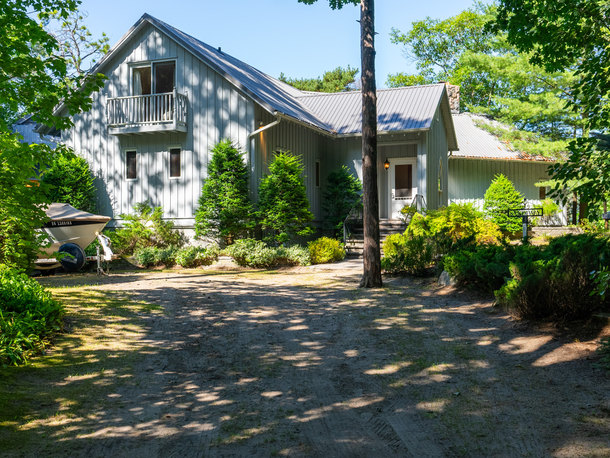 A wide driveway leads to a bit cottage.