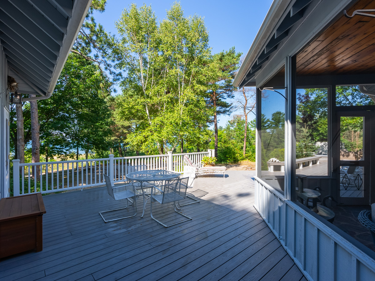 A large back deck with a small table and chairs.