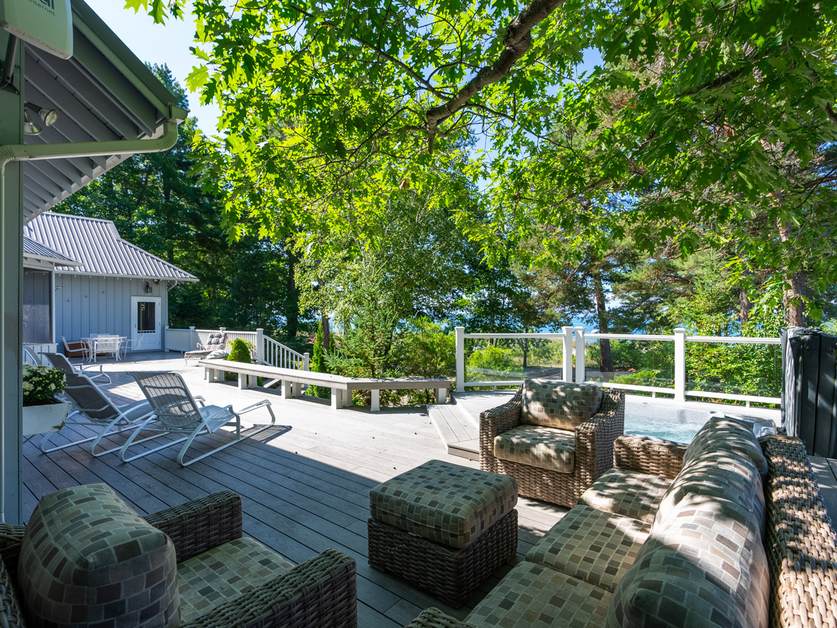An outdoor sectional couch on a large back deck.