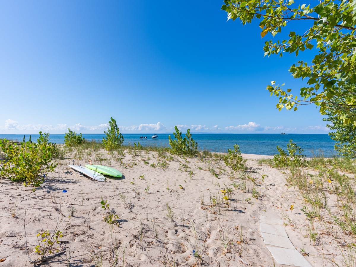 A sandy beach in front of blue water.