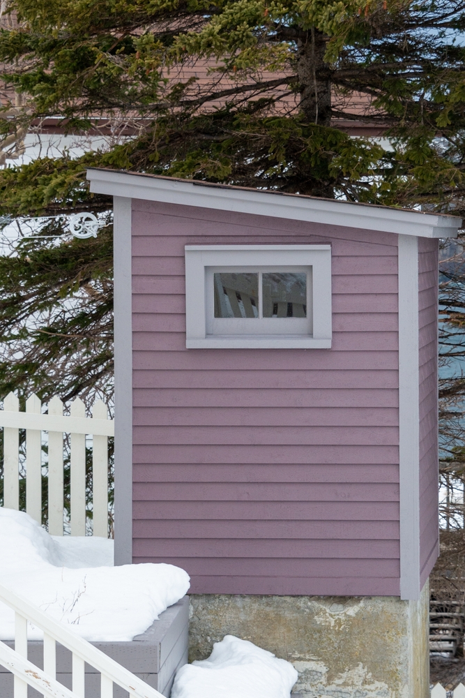 A purple outhouse with a window