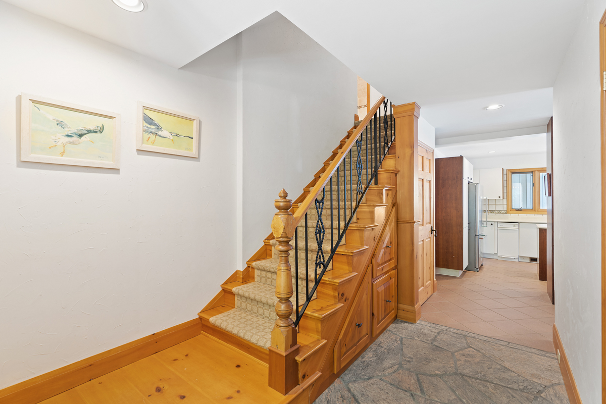 A carpeted staircase leads up to a second level in a cottage.