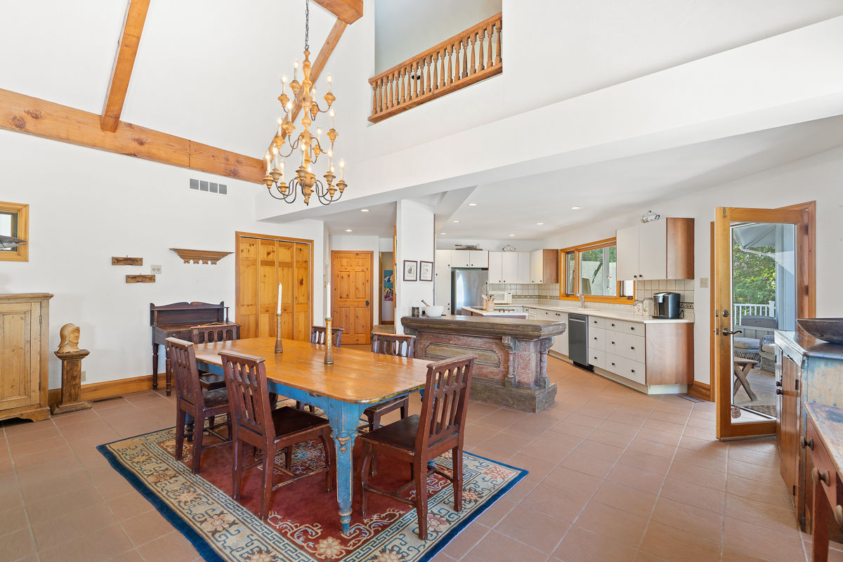 A bright, open-concept main floor space of a luxury cottage, with a dining area leading into a kitchen.