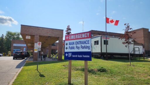 The outside of Huntsville hospital with a sign pointing towards parking