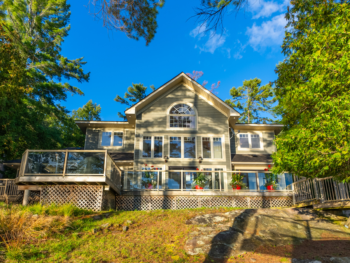 A large two-story cottage with lots of windows.