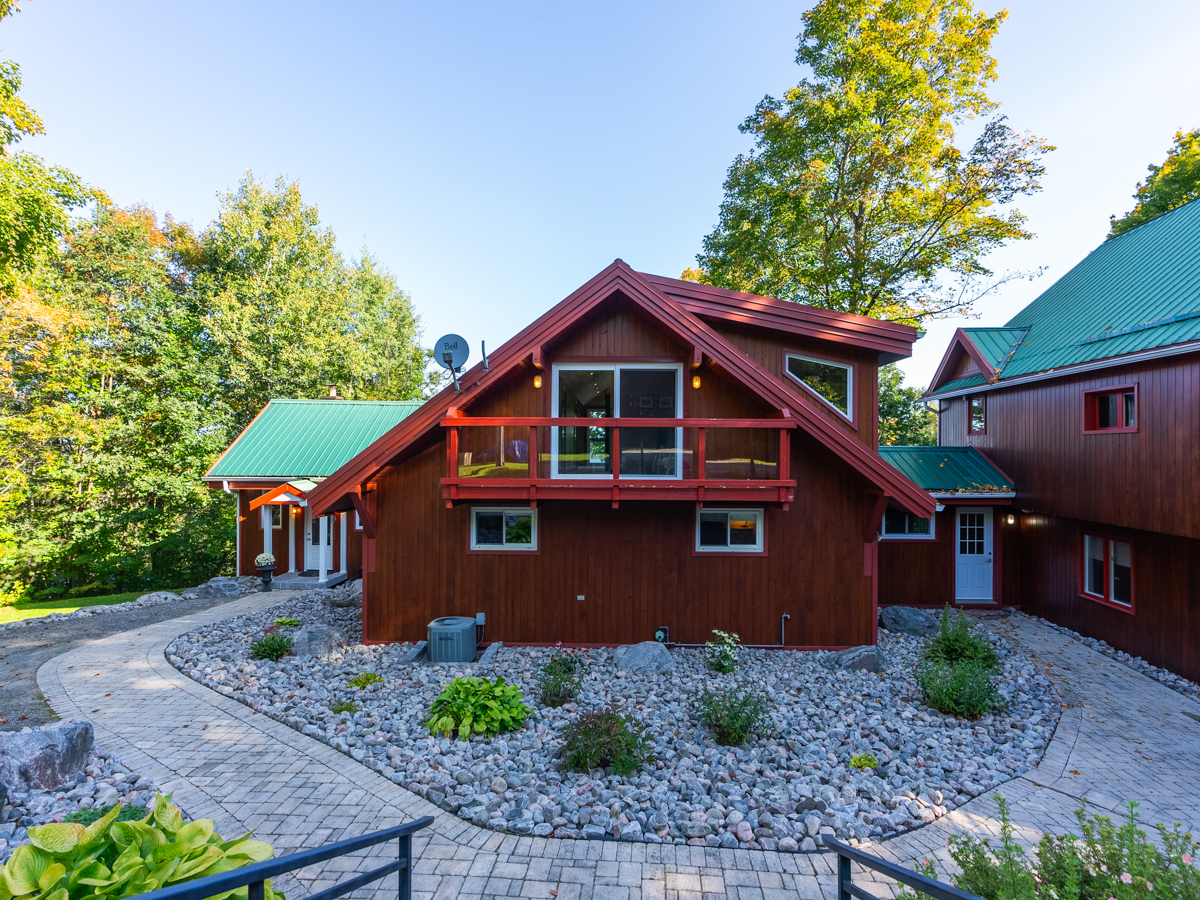 A balcony extends off the front of a cottage.