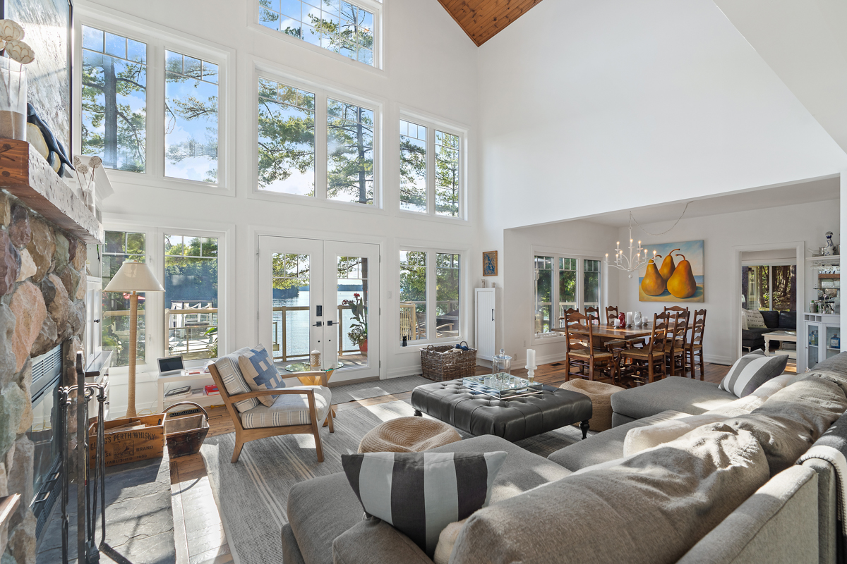 A bright, open lake house living space with vaulted ceilings, lots of windows, and plenty of seating.