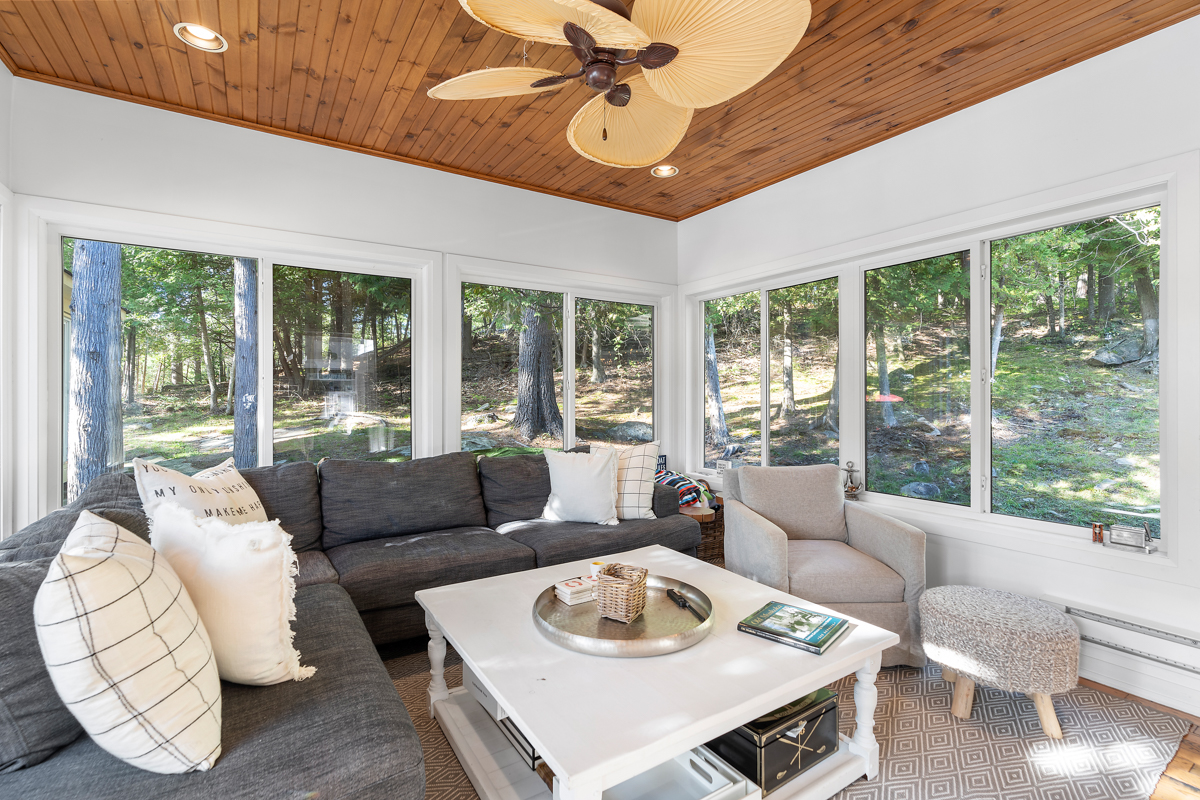 A big, bright sunroom with a wood-panelled ceiling and plenty of seating.