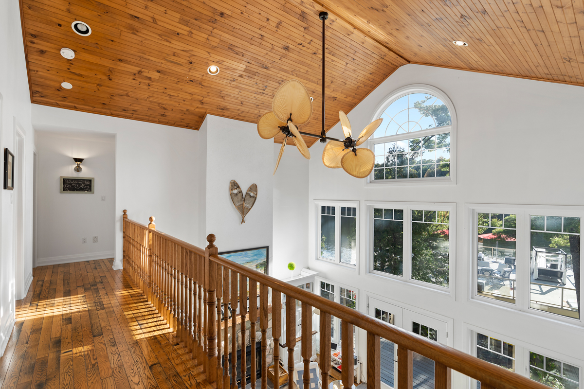 An upper-level hallway with a railing that looks out over the main floor below.