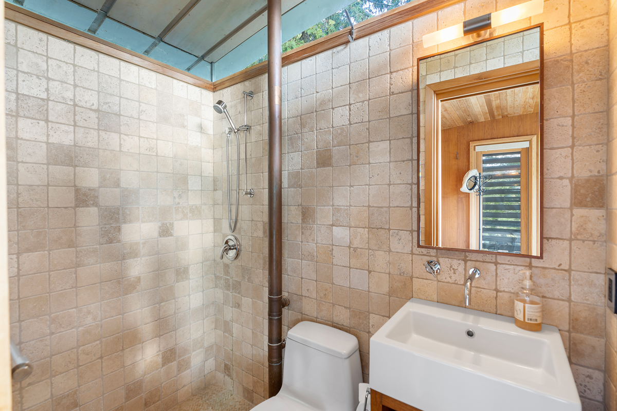 A small bathroom with a toilet, a sink, and a walk-in shower.