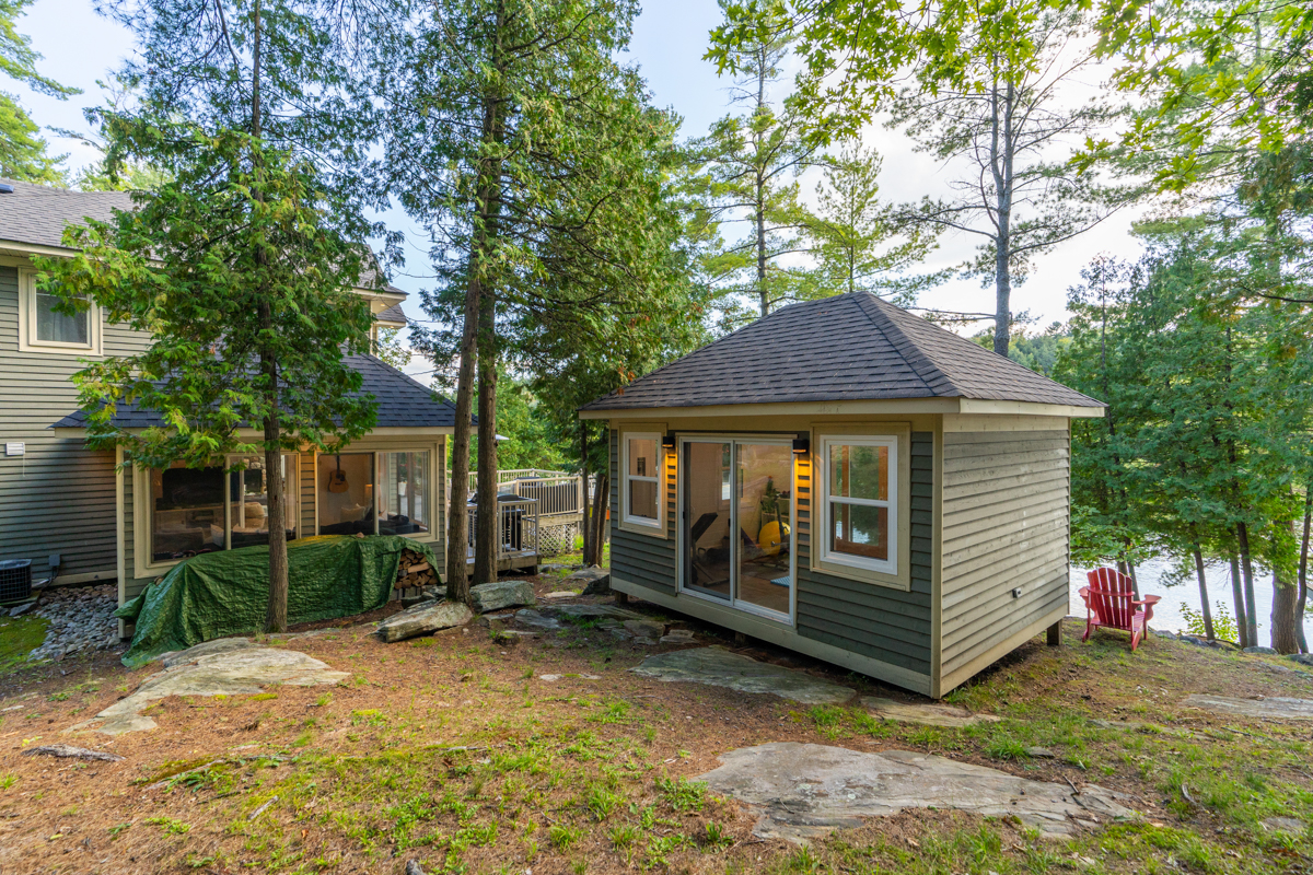 A small building sits to the side of a big lakehouse.