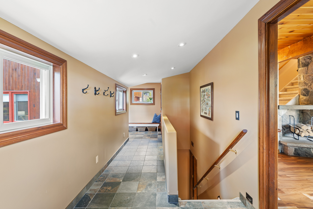A tiled hallway. Stairs lead down to a lower level on one side.