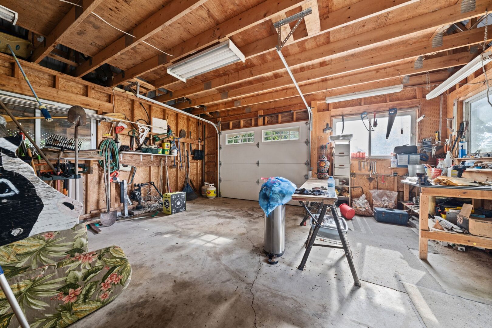 Inside a garage with lots of space for storage and a workshop area.