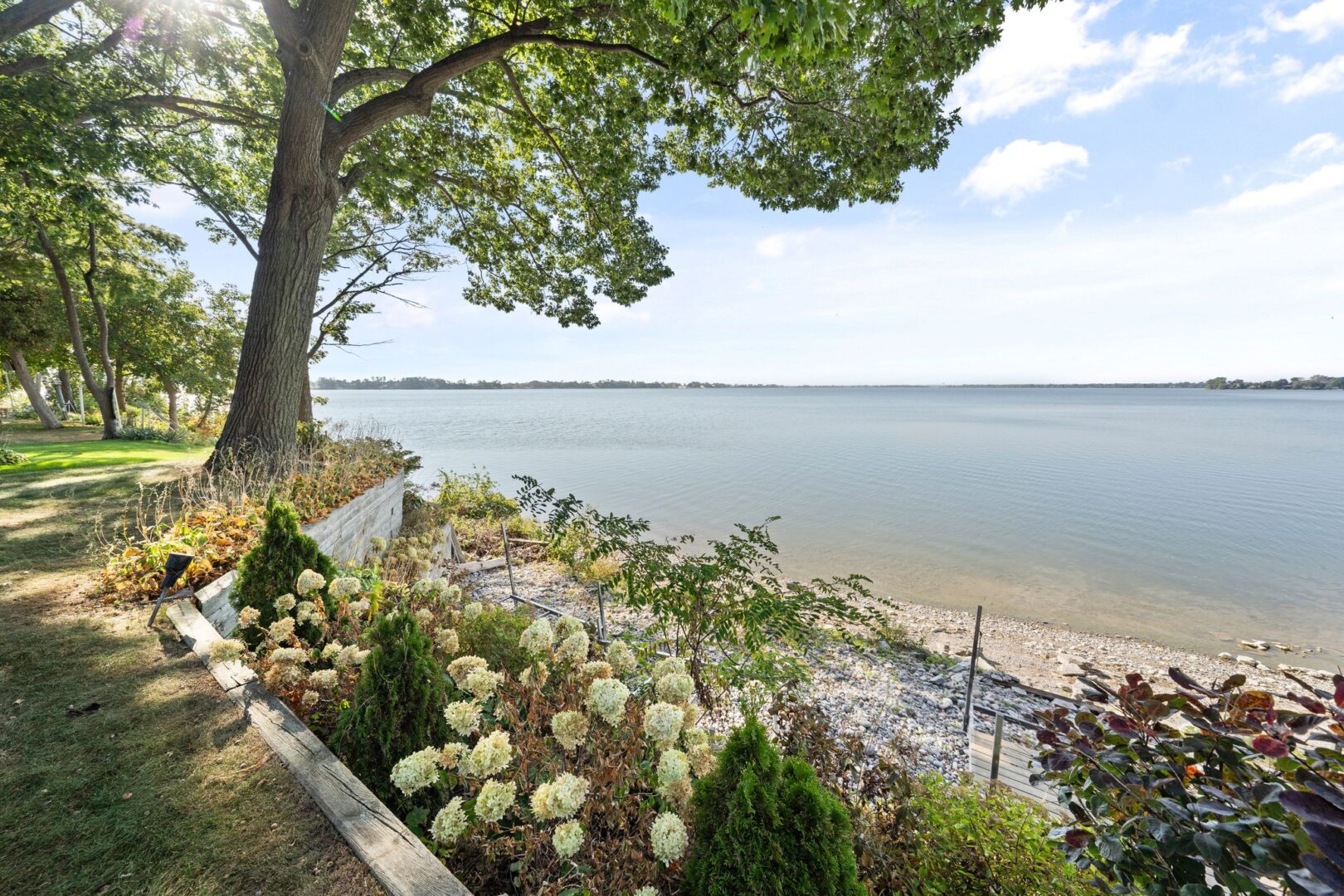 A flower garden along the edge of a shoreline of a lakefront property.