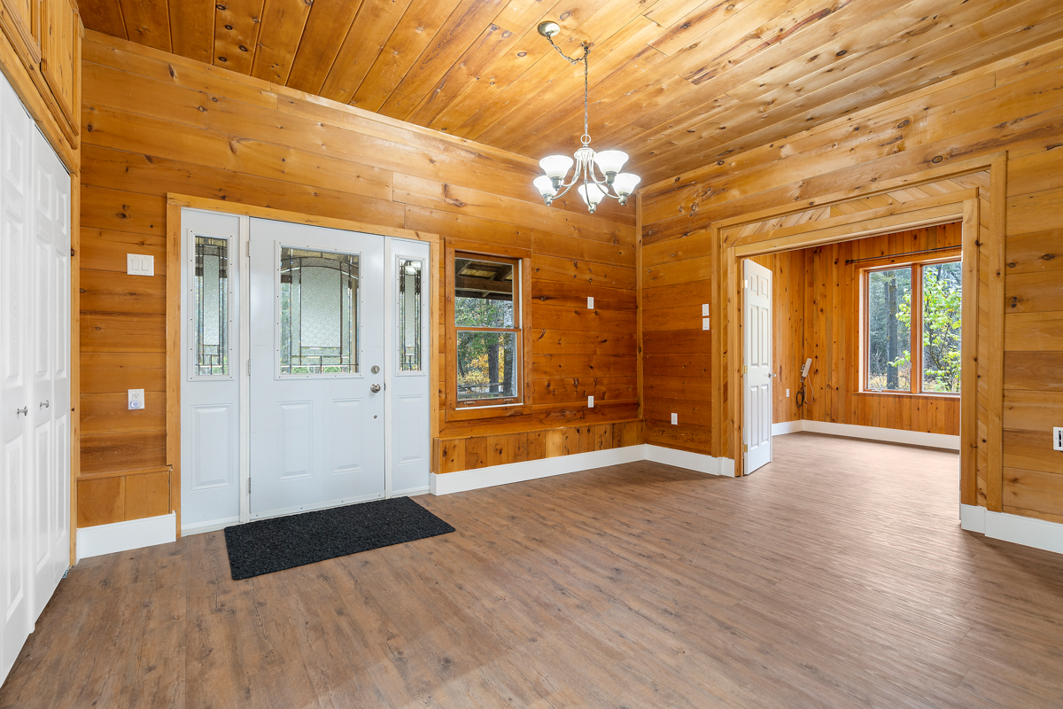 A bright, spacious front entrance area. The ceiling and walls are wood-panelled.