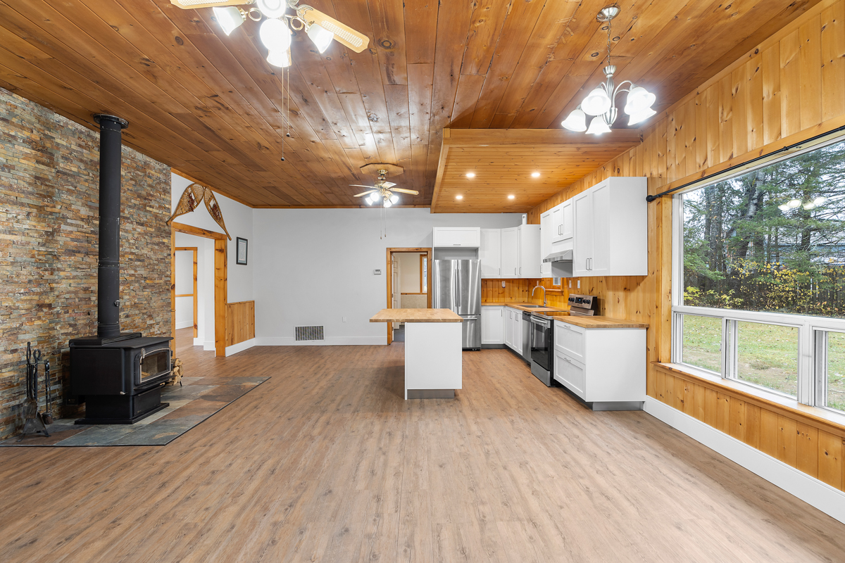 A large, open-concept space meant for living and dining, flowing into a kitchen area.