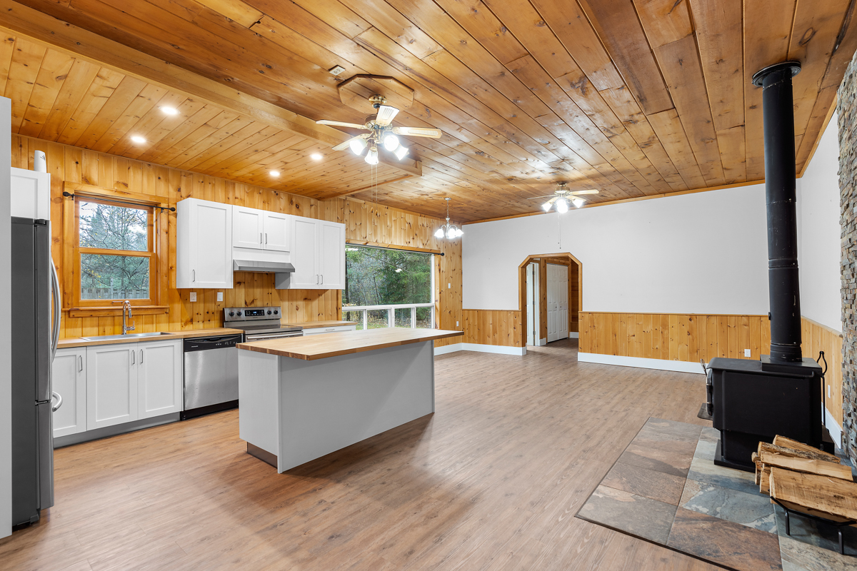 A large, open-concept space meant for living and dining, flowing into a kitchen area.