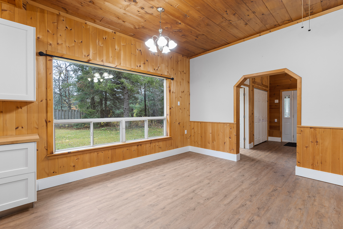 A large window in the living and dining area of a bungalow-style home.
