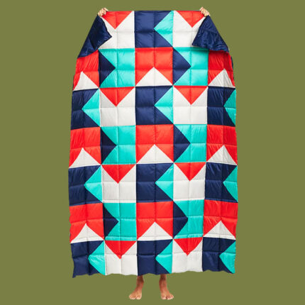 a multicoloured geometric blanket against a green background