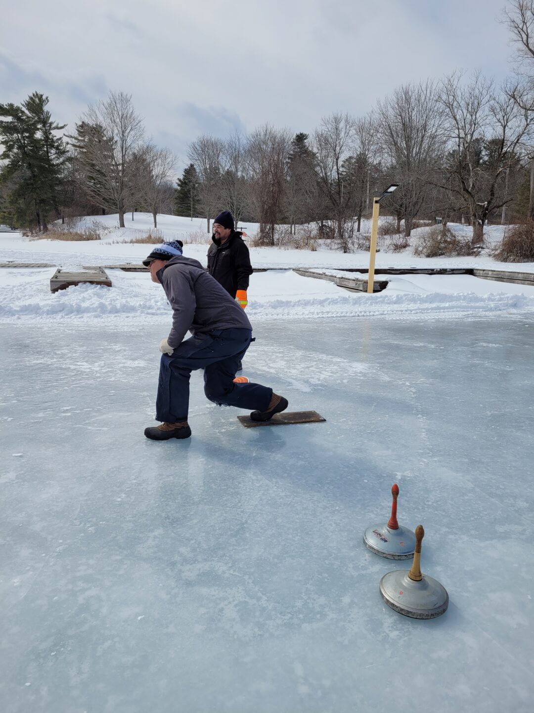 a man playing ice stock sport