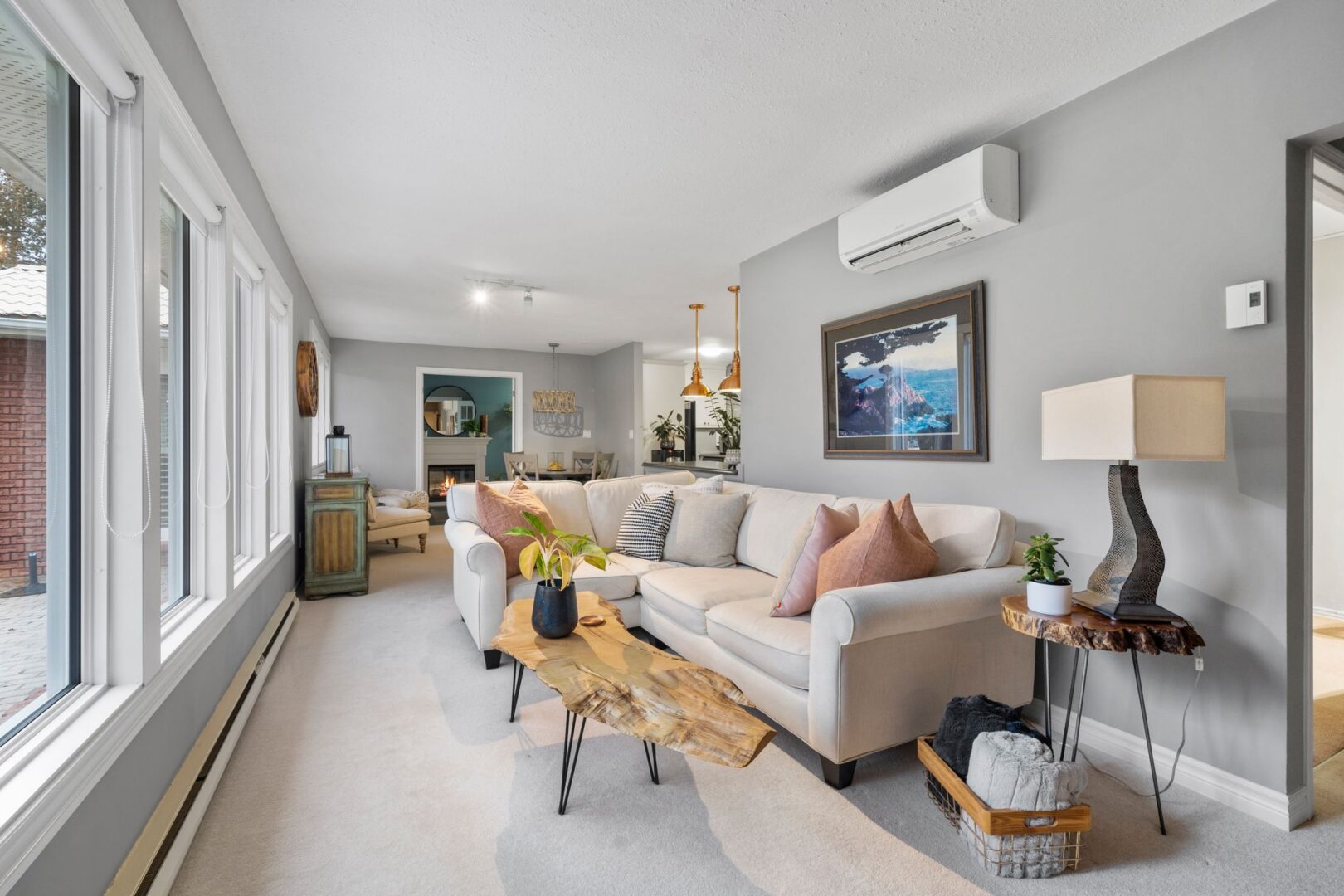 A bright and cozy living area with a large window and a big, white sectional couch.