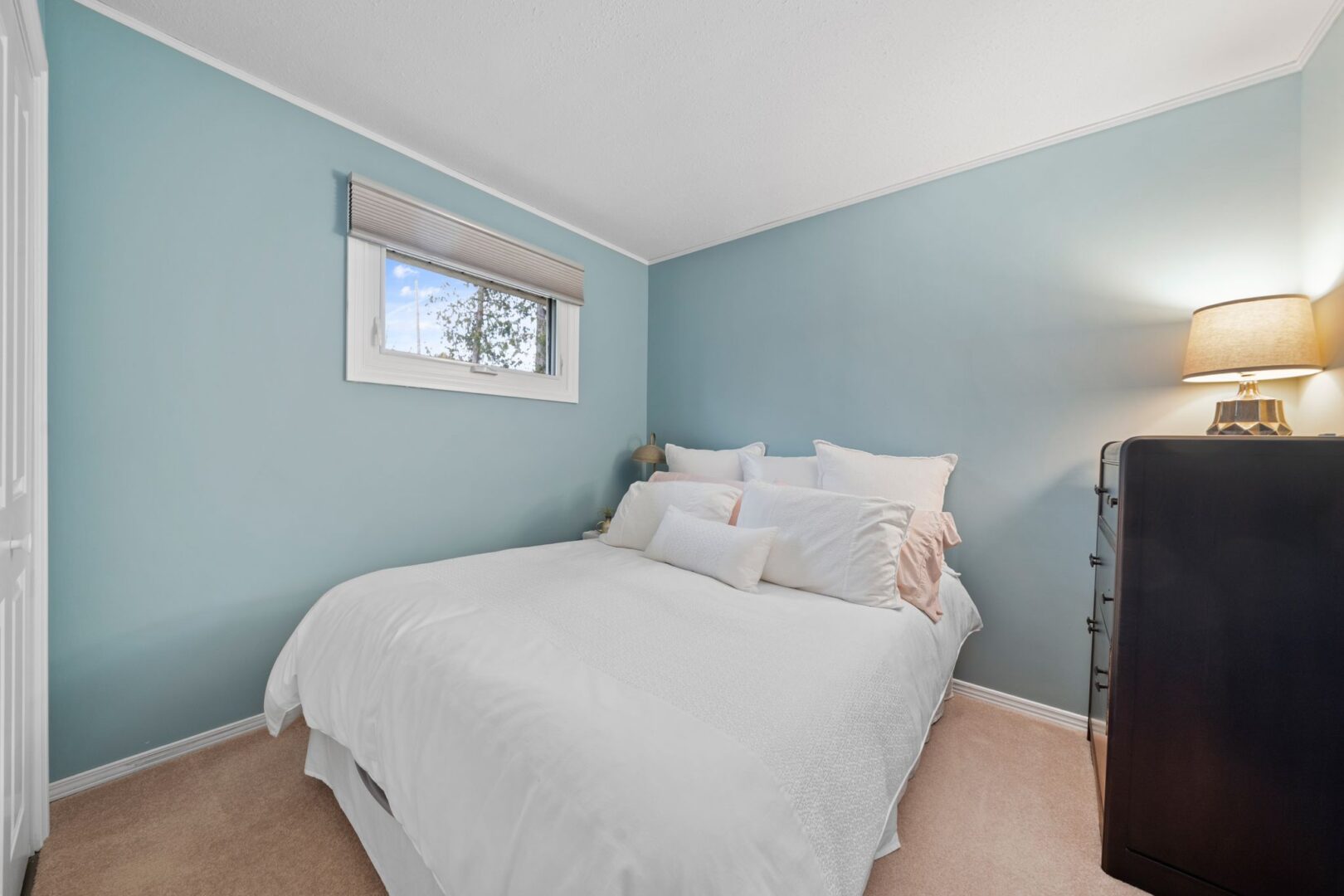 A bedroom with a big bed and light blue walls.